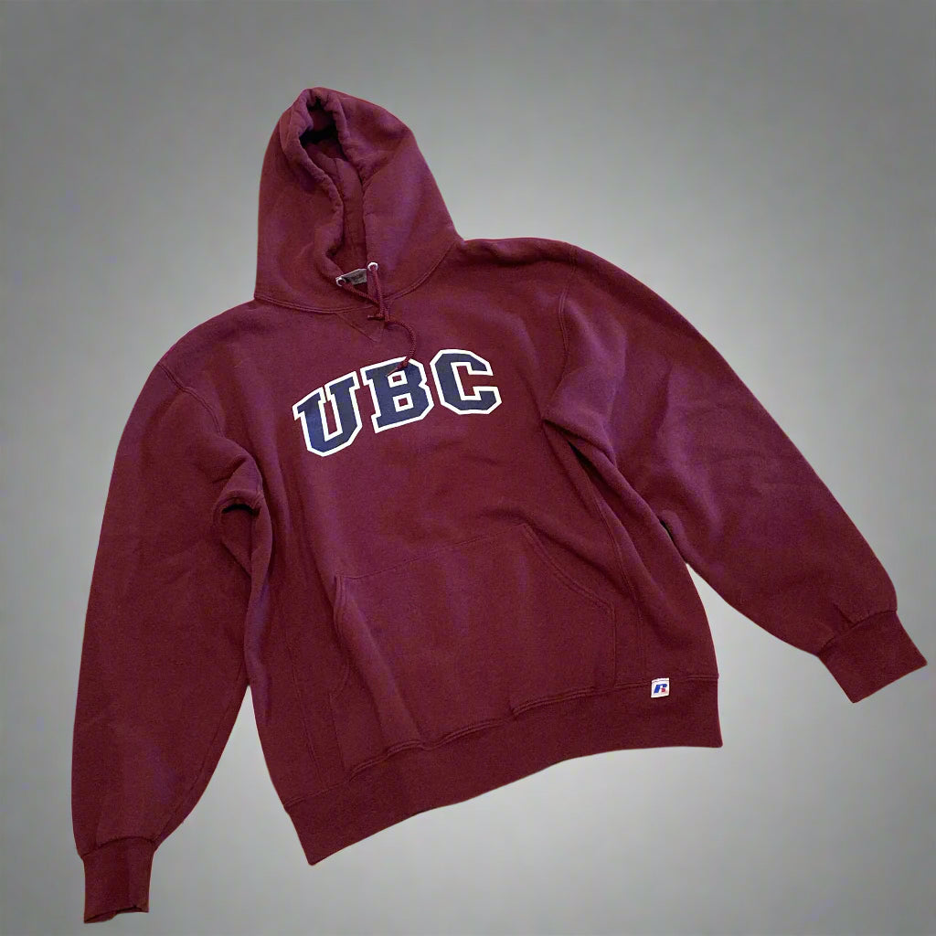 Maroon hoodie with 'UBC' text on a beige floor
