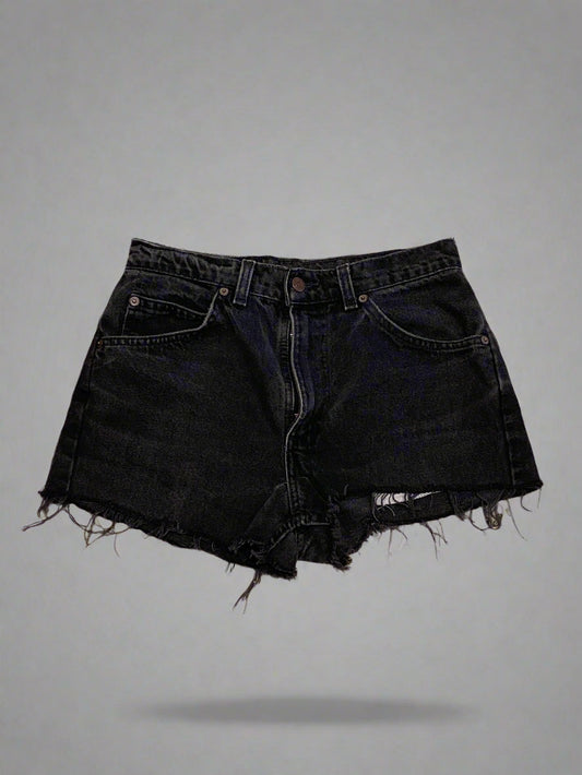 Black denim shorts on a concrete floor