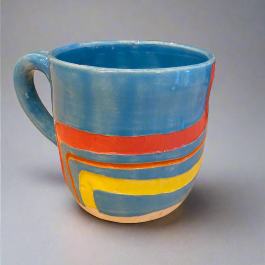 Colorful striped mug on a wooden surface